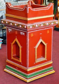 a small red and gold shrine in the middle of a room