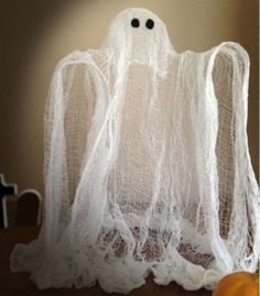 an image of a ghost made out of white yarn with eyes on it's head