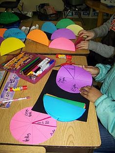 two children sitting at a table working on paper crafts with markers and crayons