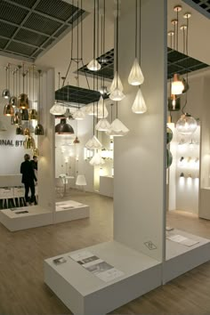 a room filled with lots of lights hanging from the ceiling next to white walls and wooden floors