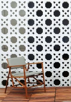 a chair sitting on top of a wooden floor next to a wall with holes in it