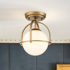 a light fixture hanging from the ceiling in a room with blue walls and gold trim