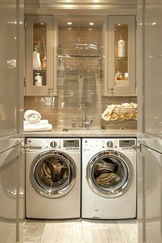 a washer and dryer in a small room with glass doors on the wall