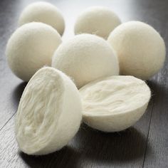 several balls of white wool sitting on top of a wooden table