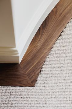 a close up view of the corner of a room with wood flooring and carpet