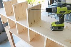 a cordless driller sitting on top of a wooden shelf