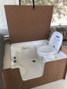 a toilet that is in the middle of a bathtub with an open lid on it