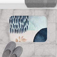 a pair of slippers sitting on top of a bathroom floor next to a rug