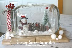 a snowman in a jar sitting on top of a wooden table