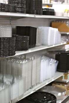 the shelves are filled with black and white plastic plates, baskets, and other items