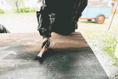 a person is sitting on a table with an object in their hand