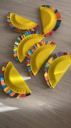 paper plate crafts are arranged in the shape of banana peels on a wooden table