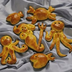 there are five little orange monkeys on the table cloths, and one is holding his hand out