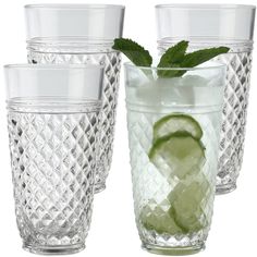 four glasses with limes and mint on them