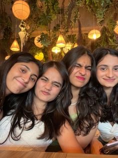 four women are posing for the camera at a restaurant