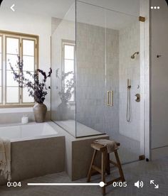 a bathroom with a tub, shower and stool next to the bathtub is shown