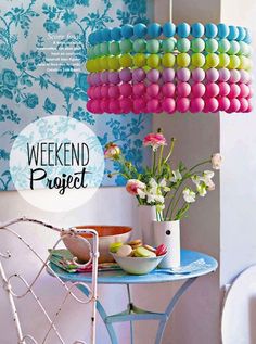 a magazine cover with colorful balloons hanging from it's ceiling and plates on the table