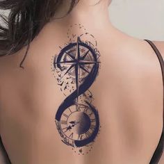 a woman's back with a compass tattoo on it