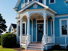 a blue house with white trim and columns