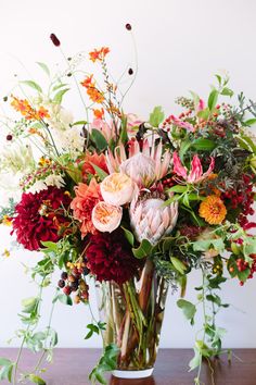 a vase filled with lots of flowers on top of a table