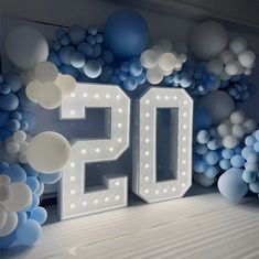 the number 50 is surrounded by balloons and streamers in blue, white and silver