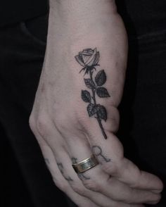 a woman's hand with a rose tattoo on it