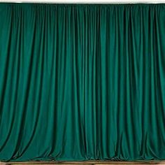 a green curtain hanging on the side of a wall