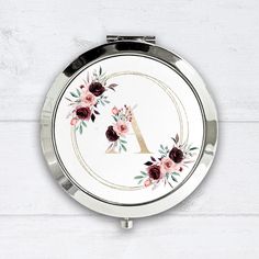 a compact mirror with flowers painted on it