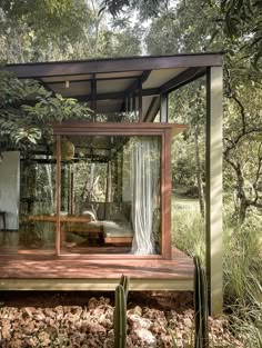 a wooden deck with a bed in the middle surrounded by greenery and trees on both sides