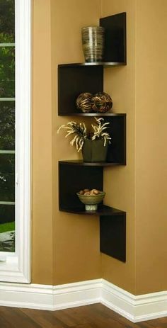 three tiered shelves with pots and bowls on them in the corner of a room