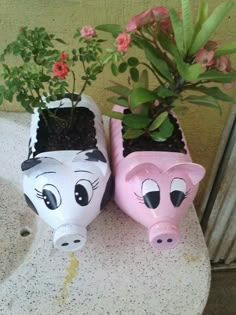 two pig planters sitting on top of a table next to a potted plant