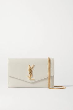 SAINT LAURENT's 'Uptown' shoulder bag makes a thoughtful gift for completists, as it comes with a matching cardholder that slots neatly inside. Made in Italy from pebbled leather that'll keep scuffs and scratches hidden, it's embellished with a gleaming gold 'YSL' logo plaque. The polished chain strap is removable, so you can carry it as a clutch, too. Wear it with: SAINT LAURENT Blazer, SAINT LAURENT Pants. -- Cream textured-leather - Snap-fastening front flap - Designer color: Crema Soft - Com Luxurious Bags, Cream Clutch, Timeless Luxury White Bag, Gold Ysl Bag, White Designer Bag, White Luxury Light Luxury Bags, Yves Saint Laurent Bag, White Ysl Bag, White Ysl Purse