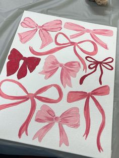 some pink and red bows on white paper