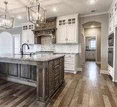 a large kitchen with an island in the middle and lots of cabinets on both sides