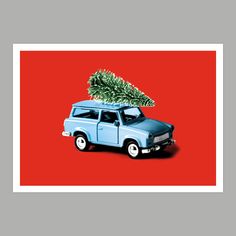 an old blue truck with a christmas tree on the roof is parked in front of a red background