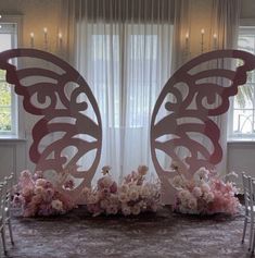 a table topped with lots of white flowers and butterfly cutouts on top of it