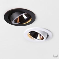 two recessed lights are shown on a white surface, one is black and the other is gold