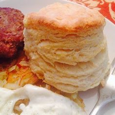 a white plate topped with pancakes, eggs and hashbrowns on top of a table