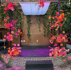 an outdoor stage decorated with pink and orange flowers