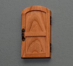 a wooden door on the side of a wall with a key in it and an opening at the top