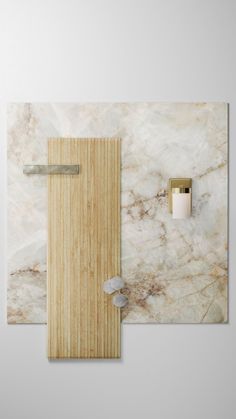 a bathroom with marble walls and wooden door, toilet paper holder and soap dispenser