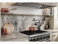 a stove top oven sitting inside of a kitchen next to a wooden cutting board and pot