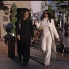 two women are walking down the sidewalk together