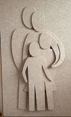 paper cut out of two people standing next to each other with an angel above them