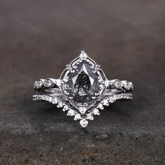 a fancy engagement ring with an intricate design on the band and center stone, set in 18k white gold