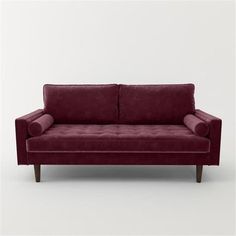 a red couch sitting on top of a white floor