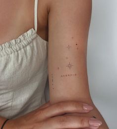 a woman's arm with a star tattoo on the left side of her arm