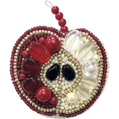 a beaded ornament with red beads and a black eye on it's face