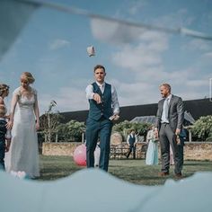 a group of people standing on top of a grass covered field next to each other