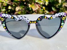 a pair of heart shaped sunglasses with letters on them